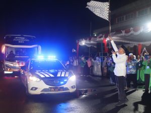 Bupati Banyumas Sadewo Tri Lastiono mengangkat bendera start untuk melepas keberangkatan bus jemaah haji Kloter 74 di halaman GOR Satria Purwokerto.