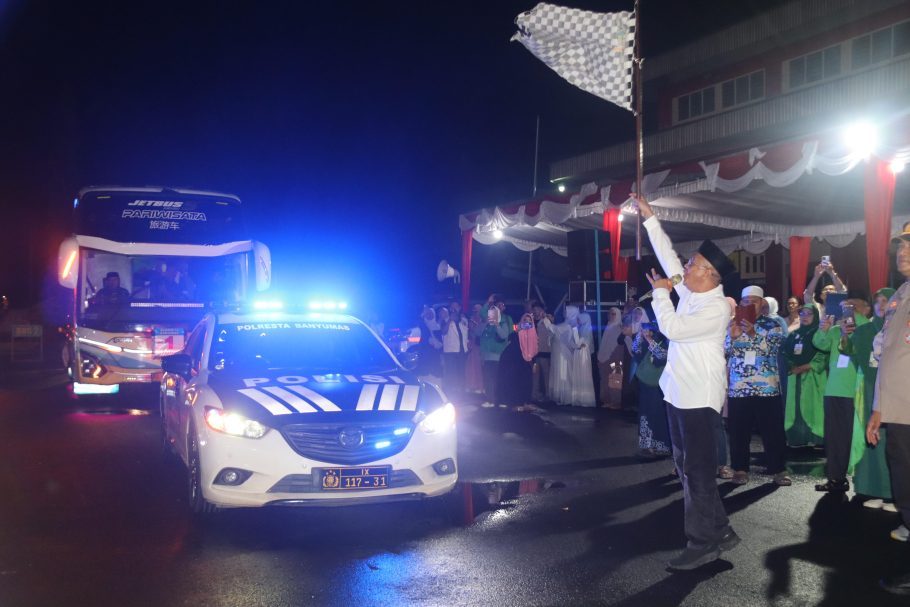 Bupati Banyumas Sadewo Tri Lastiono mengangkat bendera start untuk melepas keberangkatan bus jemaah haji Kloter 74 di halaman GOR Satria Purwokerto.