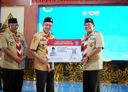 Bupati Banyumas Sadewo Tri Lastiono tersenyum saat menerima Kartu Tanda Anggota Gerakan Pramuka raksasa dalam acara pelantikan Ketua Mabicab Banyumas.