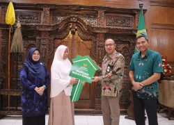 Bupati Banyumas Sadewo Tri Lastiono menyerahkan simbolis kunci rumah berbentuk replika kunci hijau kepada warga penerima manfaat program RTLH Baznas di Ruang Joko Kaiman.