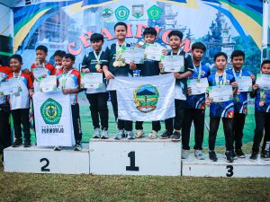 Foto bersama deretan atlet cilik panahan Kabupaten Banyumas di atas podium juara satu, dua, dan tiga sambil memegang piagam penghargaan dan mengibarkan bendera lambang daerah Perpani Banyumas pada Kejurprov Panahan Junior Jateng 2026.