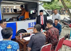 Petugas Bapenda Kabupaten Banyumas melayani warga yang memanfaatkan program pemutihan denda PBB menggunakan mobil pelayanan keliling resmi.