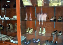 Berbagai produk kerajinan tangan lokal seperti anyaman bambu, wayang, dan gerabah tanah liat dipajang di rak kayu galeri UMKM Griya Kriya Dekranasda Banyumas.