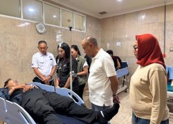Bupati Banyumas Sadewo Tri Lastiono sedang menjenguk penonton korban tribun ambruk GOR Satria yang terbaring di ranjang rumah sakit.