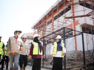 Wakil Bupati Banyumas Dwi Asih Lintarti bersama Sekda Agus Nur Hadie mengenakan rompi keselamatan dan helm putih sedang meninjau proyek pembangunan gedung fasilitas Sekolah Rakyat Banyumas yang menggunakan struktur perancah scaffolding.