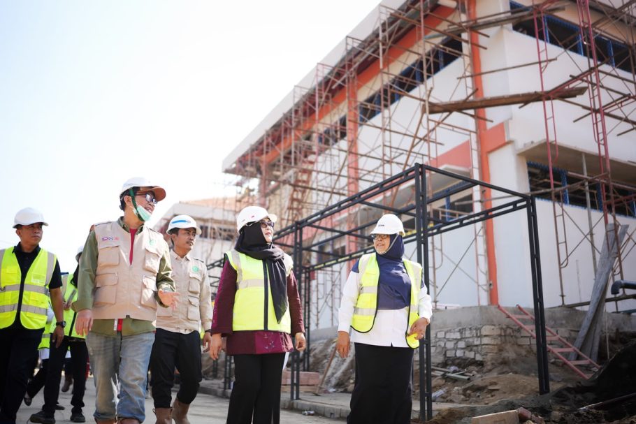 Wakil Bupati Banyumas Dwi Asih Lintarti bersama Sekda Agus Nur Hadie mengenakan rompi keselamatan dan helm putih sedang meninjau proyek pembangunan gedung fasilitas Sekolah Rakyat Banyumas yang menggunakan struktur perancah scaffolding.