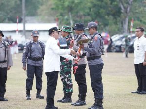 Bupati Banyumas Sadewo Tri Lastiono menyerahkan sekop secara simbolis kepada personel Linmas saat pembukaan TMMD Banyumas 2026 di Desa Cirahab, Lumbir.