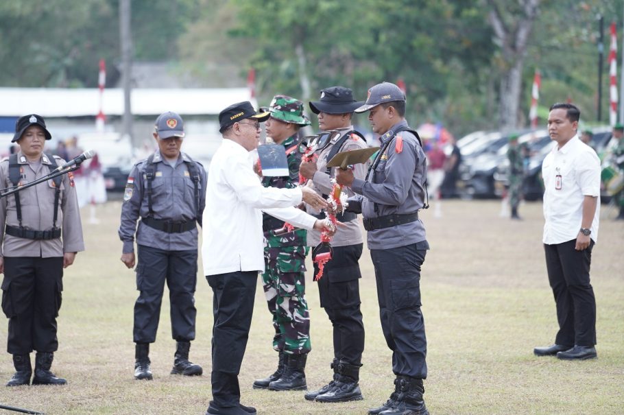 Bupati Banyumas Sadewo Tri Lastiono menyerahkan sekop secara simbolis kepada personel Linmas saat pembukaan TMMD Banyumas 2026 di Desa Cirahab, Lumbir.