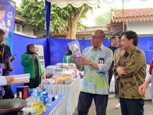 Bupati Banyumas Sadewo Tri Lastiono memegang produk olahan kuliner binaan PNM Mekaar di Pendopo Si Panji Purwokerto.