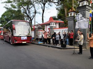Bupati Banyumas Sadewo Tri Lastiono mengibarkan bendera start melepas rombongan bus siswa berprestasi SNT 2 Banyumas di Pendopo Si Panji.