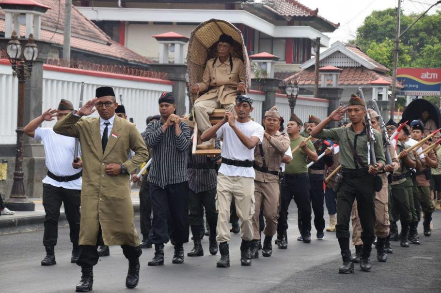 Peserta menggotong replika tandu Jenderal Soedirman didampingi rombongan berpakaian pejuang dalam Kirab Tandu Soedirman Banyumas di Alun-Alun Purwokerto.