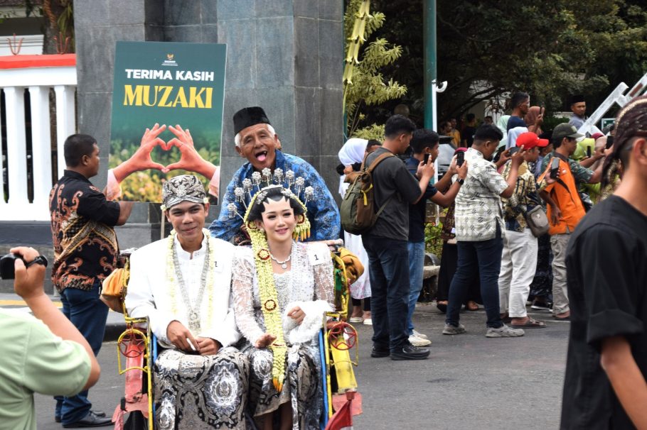 Pasangan pengantin busana adat Jawa diarak menggunakan becak hias dalam acara Nikah Gratis Banyumas Mantu 2026.