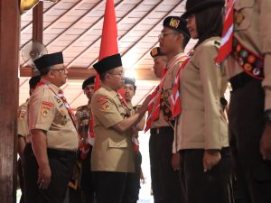 Bupati Banyumas Sadewo Tri Lastiono memasangkan kacu dan tanda pengukuhan kepada anggota Pasukan Tunas Muda 2026 di Pendopo Sipanji Purwokerto.