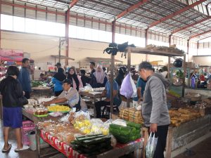 Pedagang dan pembeli melakukan transaksi jual beli di area lapak bahan pangan dan jajanan Pasar Sokaraja Banyumas.
